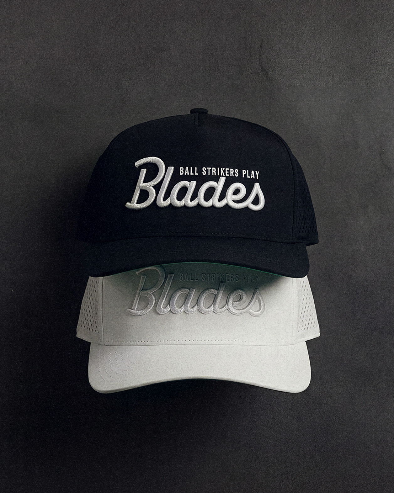 Black and white cap with 'Blades' branding on a dark background