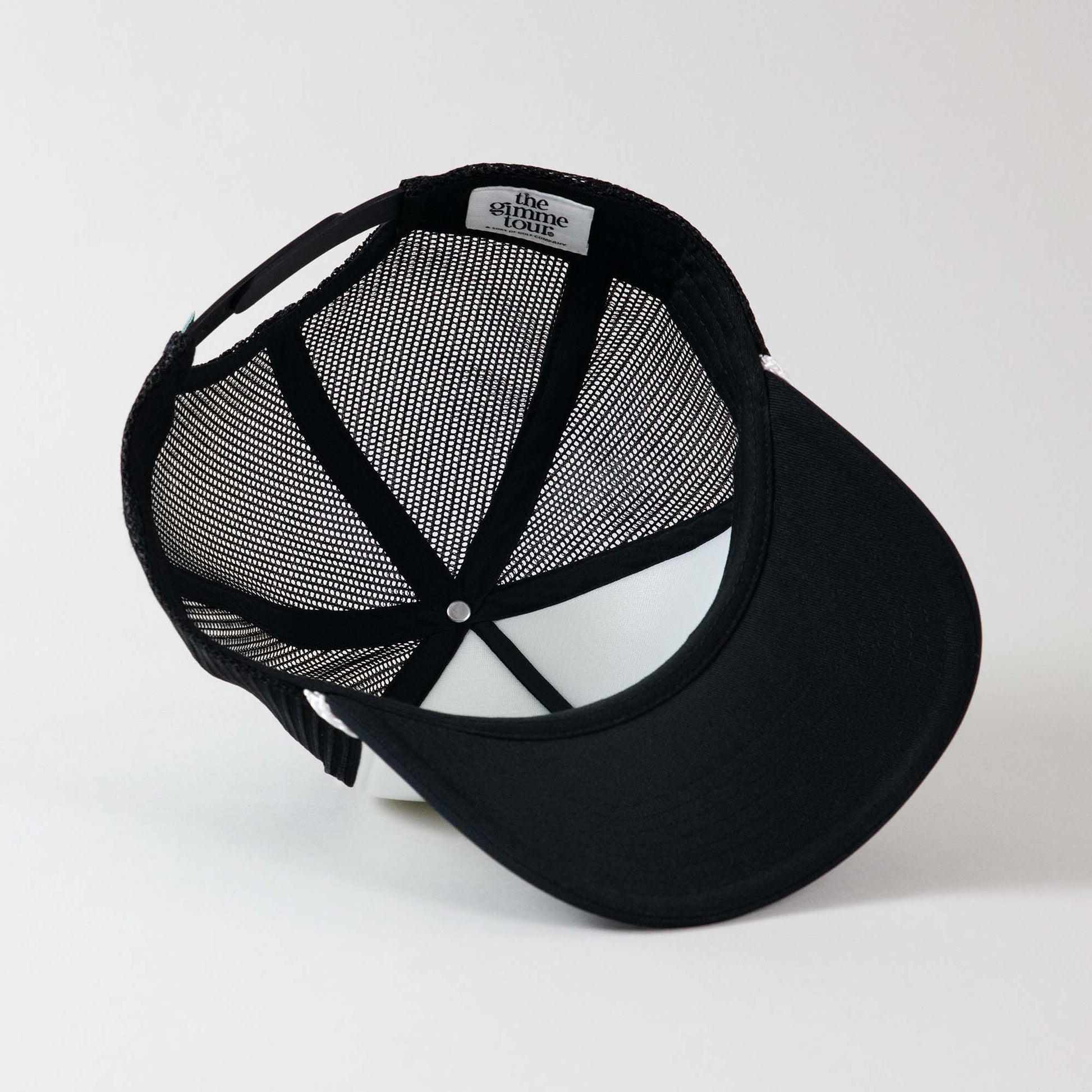 Underside view of The Gimme Tour Coke-Flakes snapback trucker hat, showing inner details and branded taping – A Sort of Golf Company.