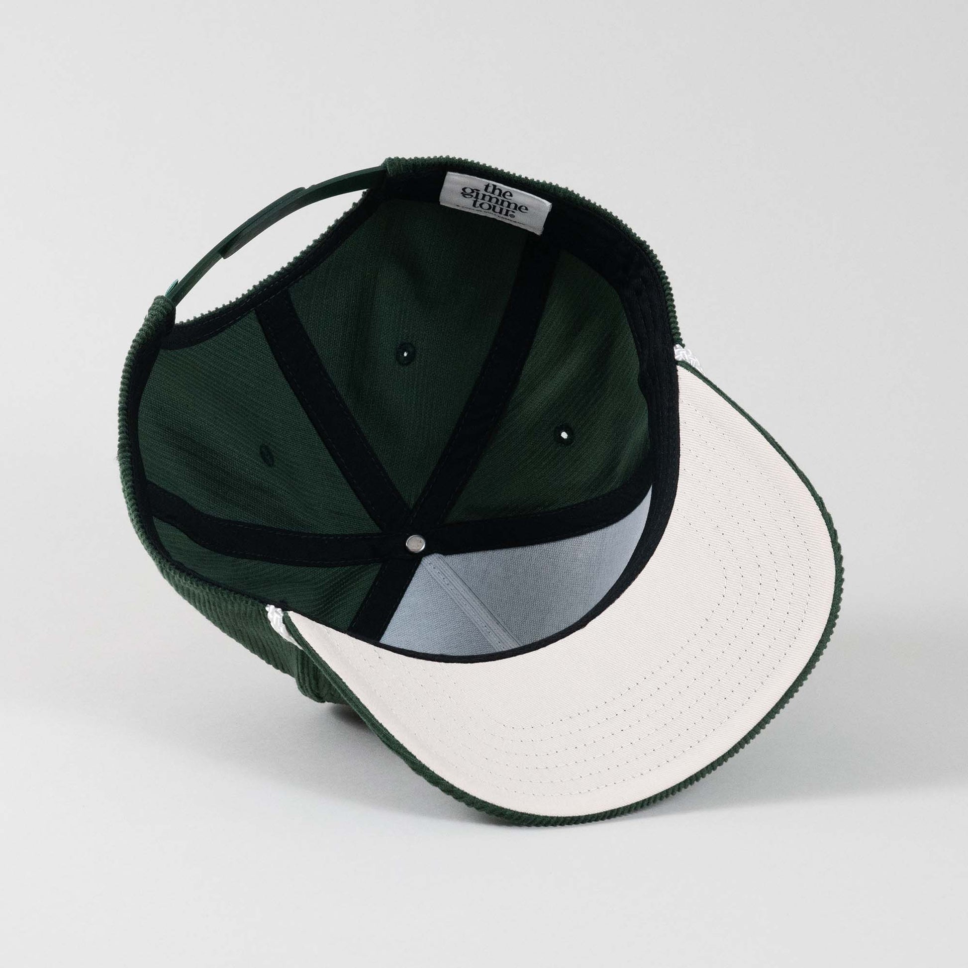 Underside view of The Gimme Tour Corduroy snapback cap, showing inner details and branded taping – A Sort of Golf Company.