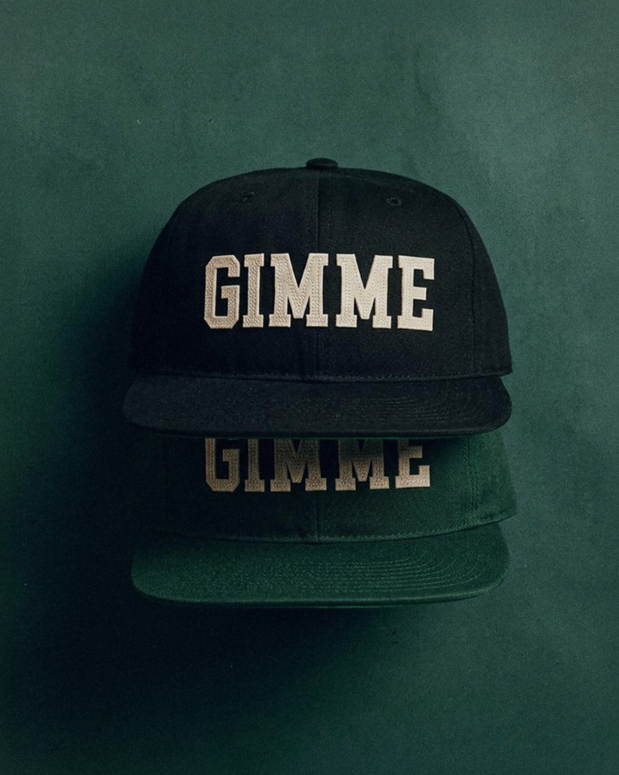 Two caps with 'GIMME' text on a green background